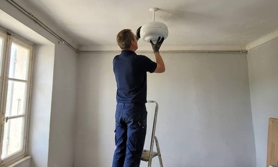 Technik inštaluje zariadenie Aquapol na odstránenie vlhkosti zo steny.