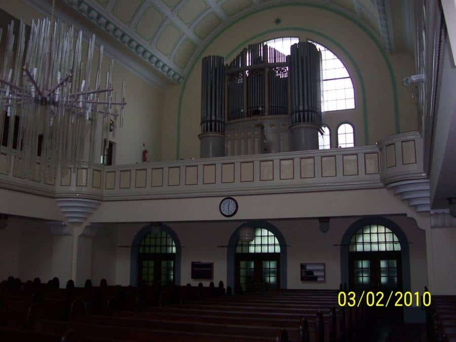 Interiér historickej budovy s organom a architektonickými detailmi.