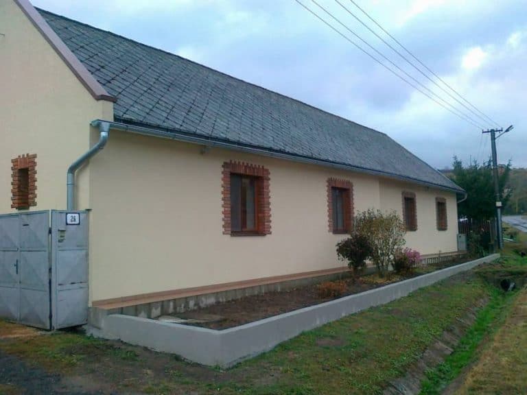 Dom so záhradou a novým plotom, ideálne na bývanie alebo rekreáciu.