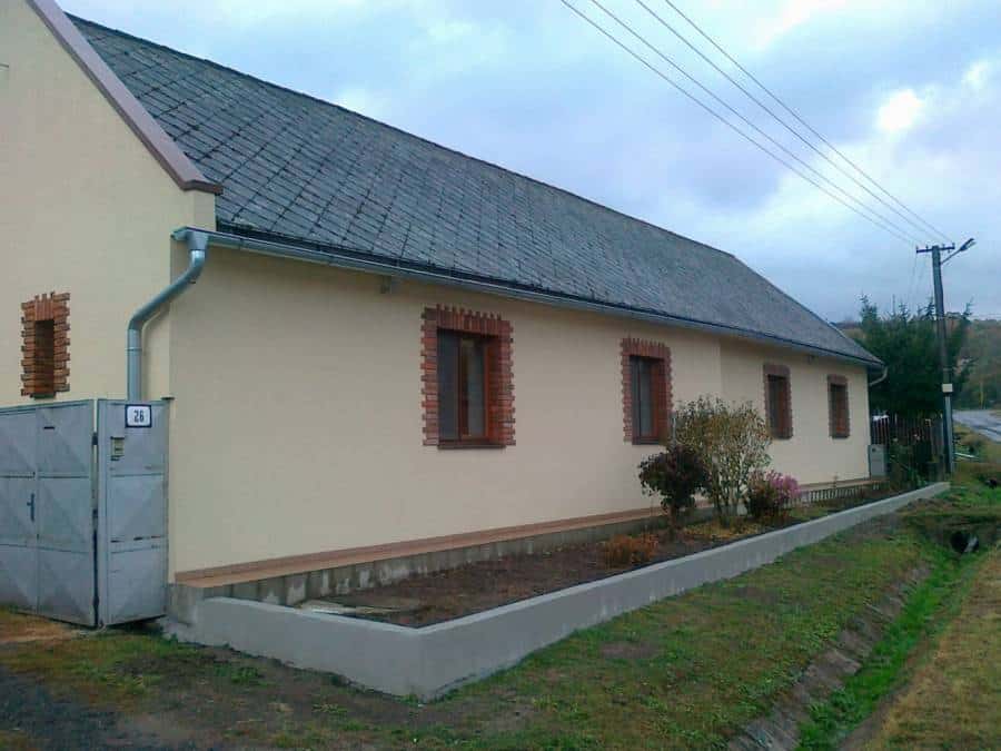 Rodinný dom s upravenou záhradou a novým plotom.
