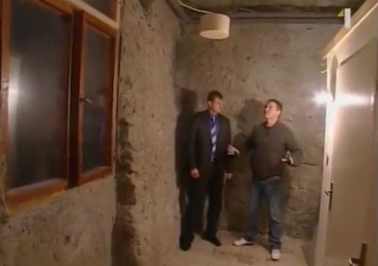 Dvaja muži diskutujú o technológii klimatizácie v interiéri budovy.
