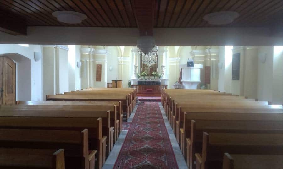 Interiér kostola s lavicami a oltárom, vhodný pre bohoslužby a sväté obrady.