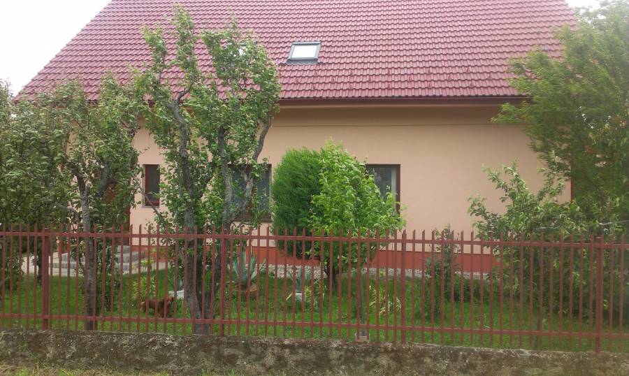 Záhradná úprava s plotom a stromami, ideálne pre ochranu a súkromie.