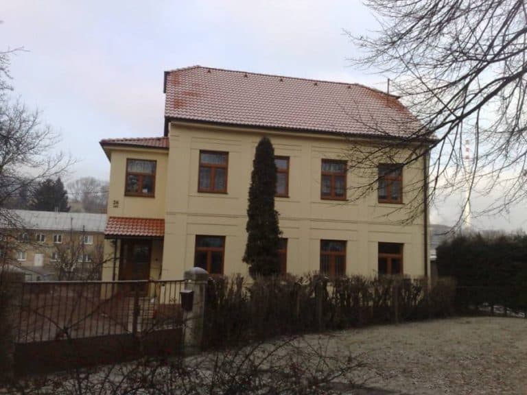 Moderná rodinná vila s veľkými oknami a záhradou, vhodná na bývanie alebo investíciu.