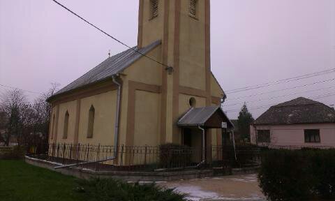 Kostolná budova s vežou na vidieku, stará architektúra.